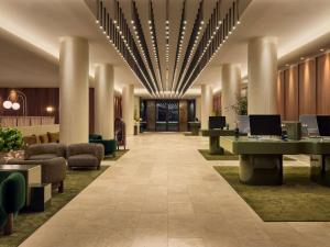 een lobby van een hotel met tafels en stoelen bij Sofitel Sydney Wentworth in Sydney