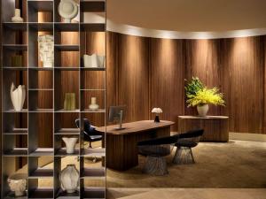 een bureau met stoelen en een boekenplank bij Sofitel Sydney Wentworth in Sydney