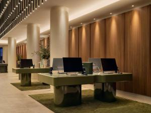 een lobby met twee bureaus met computers erop bij Sofitel Sydney Wentworth in Sydney