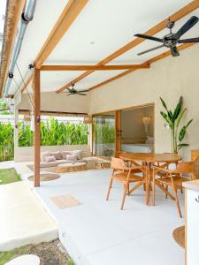 een patio met een houten tafel en stoelen bij Gili Boho Villas - Aesthetic Private Pool Villas in Gili Trawangan