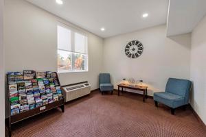 a waiting room with two chairs and a clock on the wall at Quality Inn in Ottawa