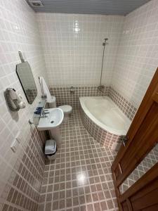 een badkamer met een toilet, een wastafel en een bad bij AntiqueShoxtut in Bukhara