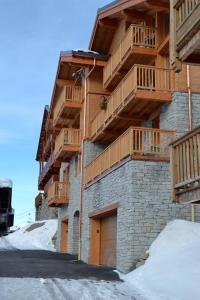 ein Gebäude mit Holzbalkonen auf der Seite in der Unterkunft Chalet Le Quartz in Val Thorens