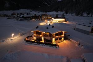 una vista aerea di una casa nella neve di notte di Alp Apart Niederthai a Umhausen