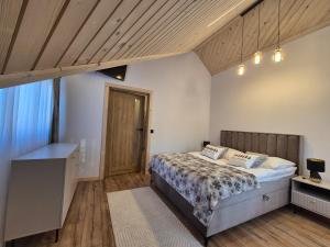 - une chambre avec un lit et un plafond en bois dans l'établissement Apartament z jacuzzi U Parów, à Białka Tatrzańska