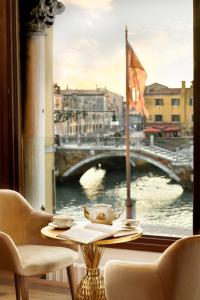 uma mesa com vista para uma ponte a partir de uma janela em Swan Dolce Vita em Veneza