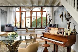 uma sala de estar com um piano e uma mesa de vidro em Swan Dolce Vita em Veneza