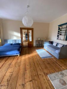 a living room with blue beds and a wooden floor at Apartmány v pivovaru in Kašperské Hory