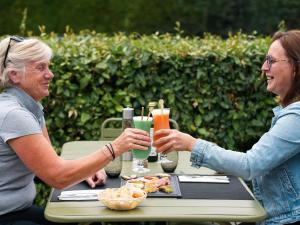 twee oudere vrouwen aan een tafel met drankjes bij ibis Caen Porte d’Angleterre in Hérouville-Saint-Clair