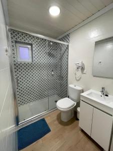 een badkamer met een douche, een toilet en een wastafel bij Granny´s Guesthouse in Praia de Mira