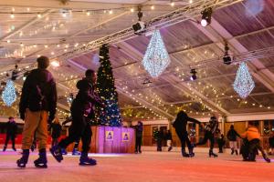 un groupe de personnes patinant dans un bâtiment avec un arbre de Noël dans l'établissement Leopold Hotel Ostend, à Ostende