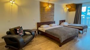 Un dormitorio con 2 camas y una silla. en Lion, en Bukovel