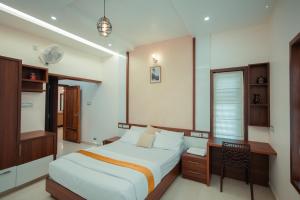 Schlafzimmer mit einem Bett, einem Schreibtisch und einem Tisch in der Unterkunft The Tales - Luxury Private Pool Resort in Kozhikode