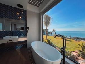 uma casa de banho com banheira e vista para o oceano em Du Parc Mũi Né Resort - ꜱᴀɴᴅ ᴅᴜɴᴇ & ᴏᴄᴇᴀɴ ᴠɪᴇᴡ em Mui Ne