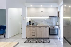 een keuken met witte kasten en een fornuis bij P&K LUXURY APARTMENTS 2 in Kalamata