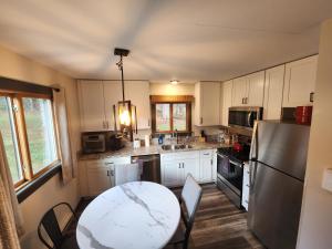 una cucina con tavolo e frigorifero di Ski in/out Spruce Glen Townhomes on Great Eastern Trail a Killington