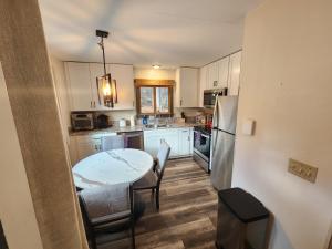 una cucina con armadi bianchi, tavolo e sedie di Ski in/out Spruce Glen Townhomes on Great Eastern Trail a Killington