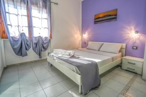 a bedroom with a bed with a purple wall at Silvia Casa Vacanze in Porto Cesareo