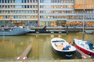 un grupo de barcos atracados en un puerto deportivo con un edificio en De Coaster & Aquarium, en Róterdam