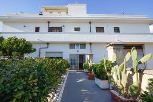 a white building with plants in front of it at Silvia Casa Vacanze in Porto Cesareo