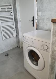 - un lave-linge et un sèche-linge blancs dans la chambre dans l'établissement Studio Le Petit Baigneur, à Aytré