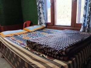 Ένα ή περισσότερα κρεβάτια σε δωμάτιο στο ROOP MOUNTAIN HOMESTAY