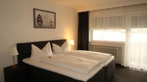 a bedroom with a bed with white sheets and a window at Hotel Zur Kripp in Koblenz