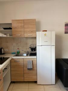 cocina con nevera blanca y fregadero en Sisifou Hostel, en Korinthos