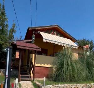 ein kleines Haus mit einer Veranda und einer Treppe dahin in der Unterkunft Sunshine villa Dzhigurovo in Sandanski