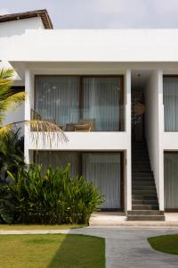 ein weißes Haus mit Glastüren und Treppen in der Unterkunft Sikara Lombok Hotel in Kuta Lombok