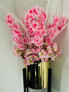 um vaso com flores cor-de-rosa em Hill Town Guest House Islamabad em Islamabad