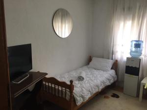 Rooms Struga في ستروغا: غرفة نوم صغيرة مع سرير ومرآة