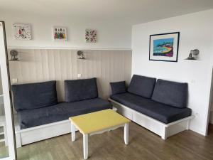 een woonkamer met een bank en een tafel bij Cap Morgat in Crozon