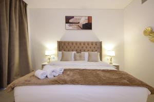 um quarto com uma cama grande e toalhas em Silk Valley - Gorgeous 4b Near Al Hamriyah em Sharjah