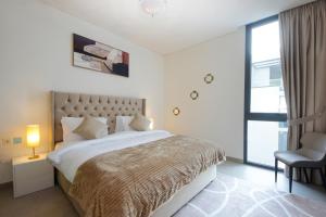 um quarto com uma cama grande e uma cadeira em Silk Valley - Gorgeous 4b Near Al Hamriyah em Sharjah