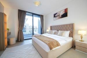 um quarto com uma cama grande e uma janela grande em Silk Valley - Gorgeous 4b Near Al Hamriyah em Sharjah