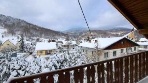 uma vista a partir de uma varanda de uma aldeia coberta de neve em Pod Zapalenicą w centrum em Szczyrk