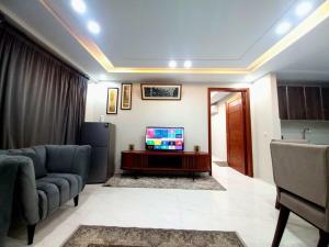 Elysium Tower Signature Serviced Apartments Islamabad في اسلام اباد: غرفة معيشة بها أريكة وتلفزيون