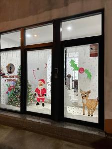 Uma janela com o Pai Natal e um cão numa exposição de Natal. em Aral Hostel em Berati