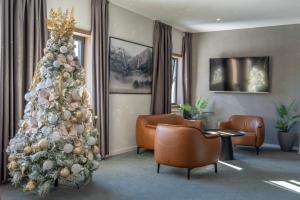 - un arbre de Noël dans un salon avec des chaises dans l'établissement Hotel Rajska dolina Jahorina, à Jahorina