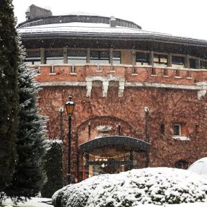 um grande edifício de tijolos com neve no chão em Citadel Gastro Boutique Hotel em Lviv