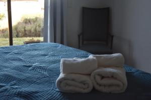 ein Bett mit zwei Handtüchern darüber in der Unterkunft cuatro lunas hotel in Punta Del Diablo