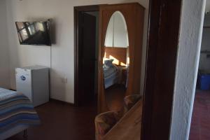 einen Spiegel in einem Zimmer mit einem Bett und einem Schlafzimmer in der Unterkunft cuatro lunas hotel in Punta Del Diablo