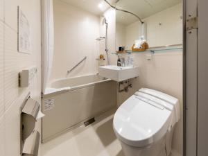 een witte badkamer met een toilet en een wastafel bij Nishitetsu Hotel Croom Nagoya in Nagoya