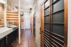 高松市にあるKotori Coworking & Hostel Takamatsuのバスルーム(木製のドア、シンク付)