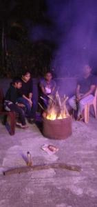 a group of people sitting around a fire pit at Rock peak view homestay in Avathi