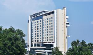 科钦Four Points by Sheraton Kochi Infopark的一座高大的白色建筑,上面有标志