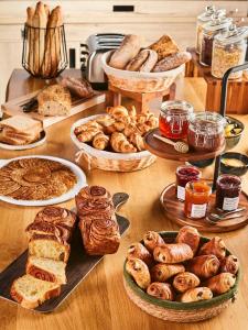 - une table avec de nombreux types de pain et de viennoiseries dans l'établissement Campanile Toulouse Sud-Labège innopole, à Labège