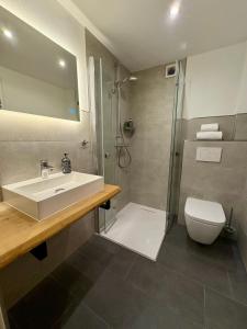 a bathroom with a sink and a shower and a toilet at Berghotel Hohegeiß in Hohegeiß