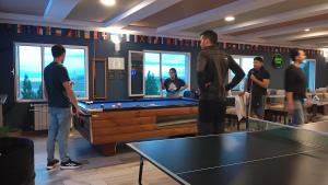 eine Gruppe von Menschen, die um einen Billardtisch stehen in der Unterkunft Viajero Calafate Hostel in El Calafate